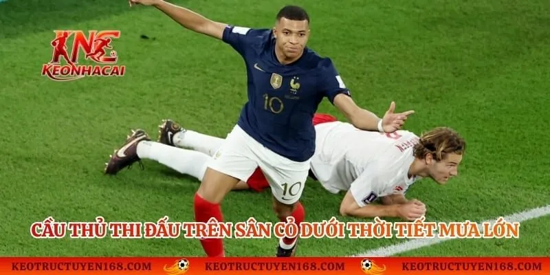 Cầu thủ thi đấu trên sân cỏ dưới thời tiết mưa lớn